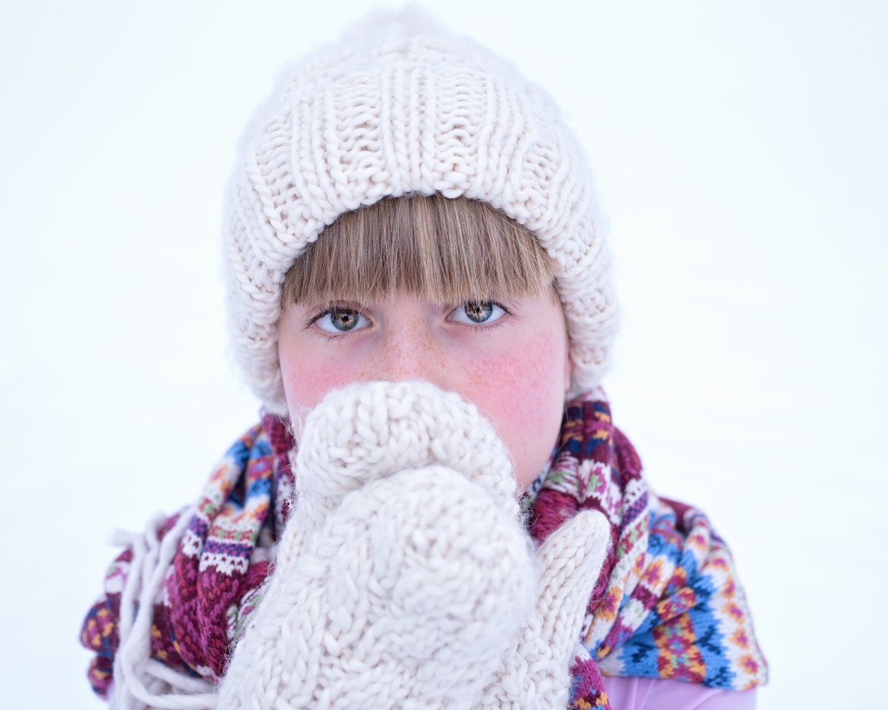 Девочка в рукавицах и белой шапке