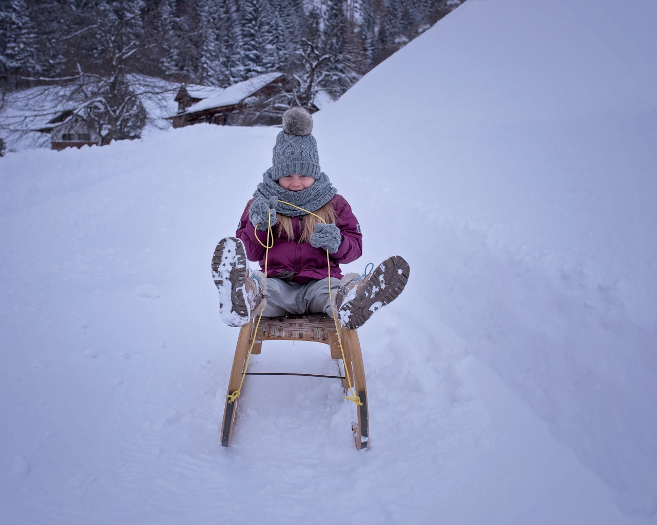 Девочка едет на санках с горки