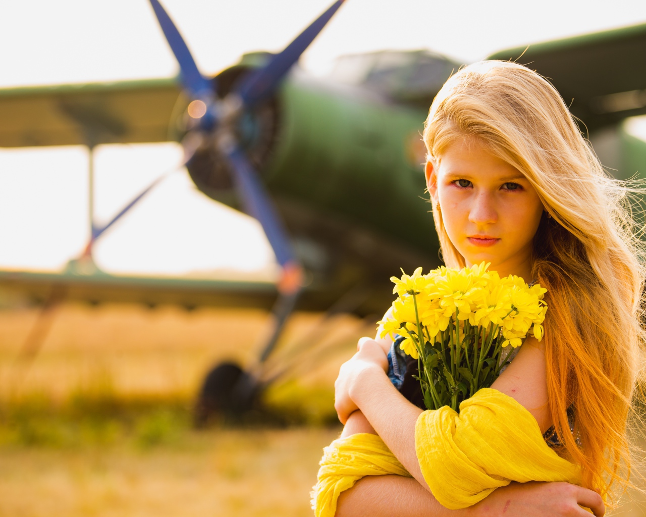 Девочка с букетом желтых хризантем у самолета 