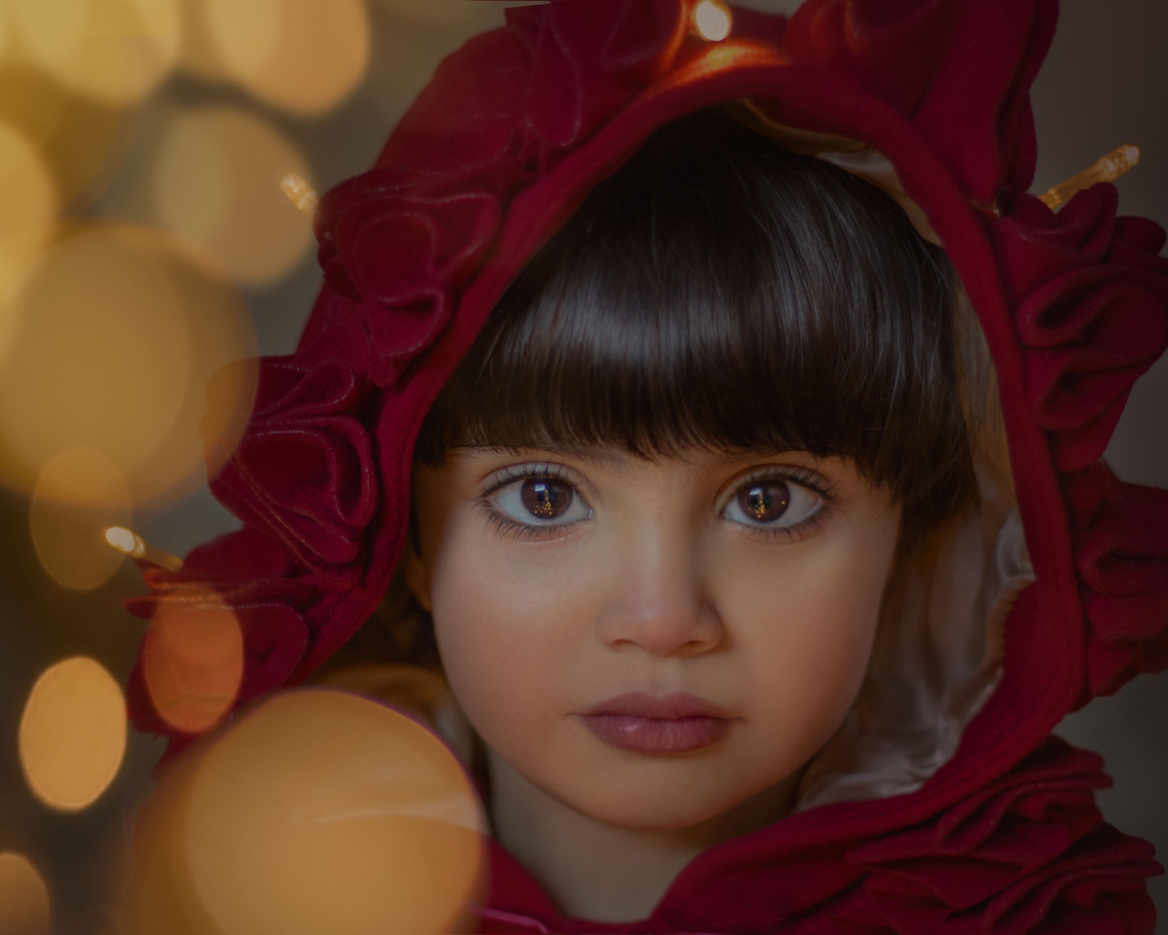 Девочка с большими карими глазами в красном капюшоне