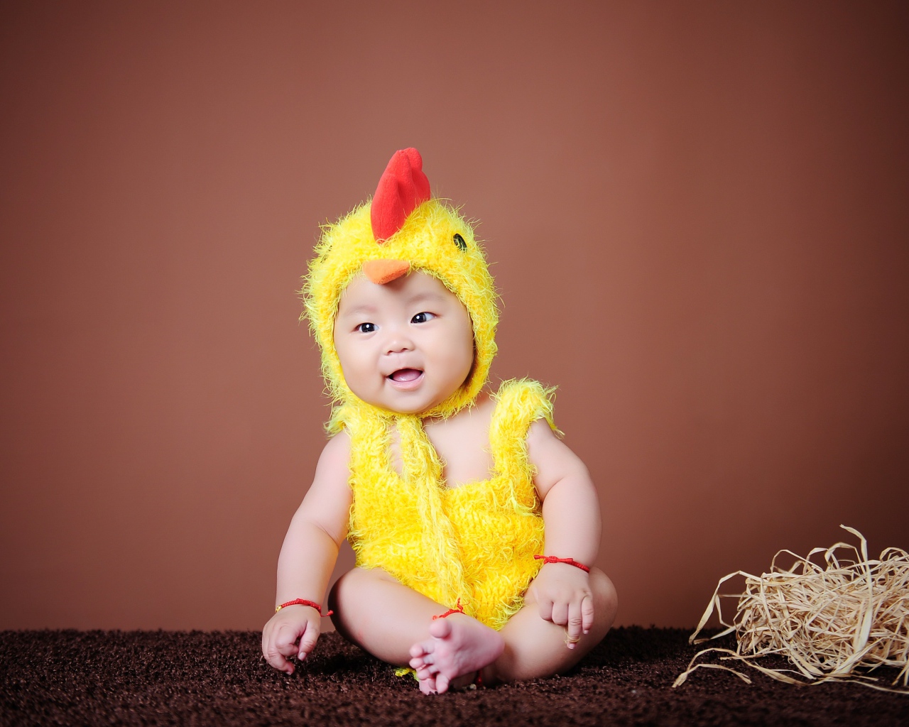 Маленький мальчик азиат в костюме цыпленка