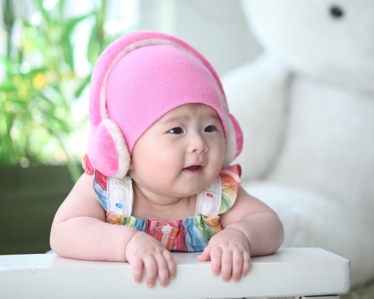 Маленький ребенок азиат в розовой шапке 