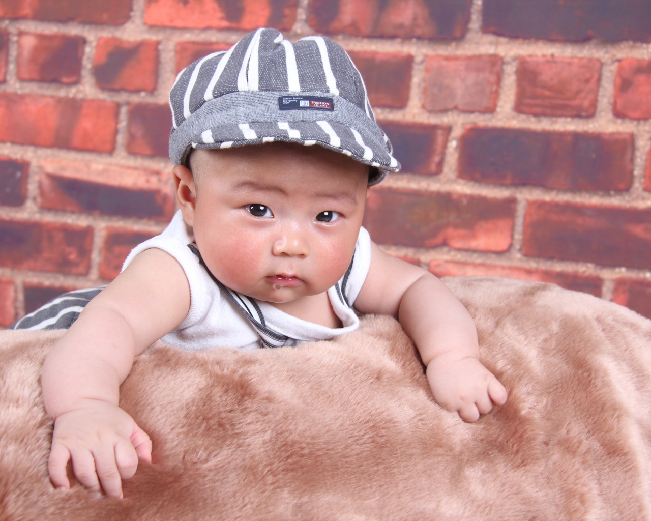 Маленький азиатский ребенок на фоне стены