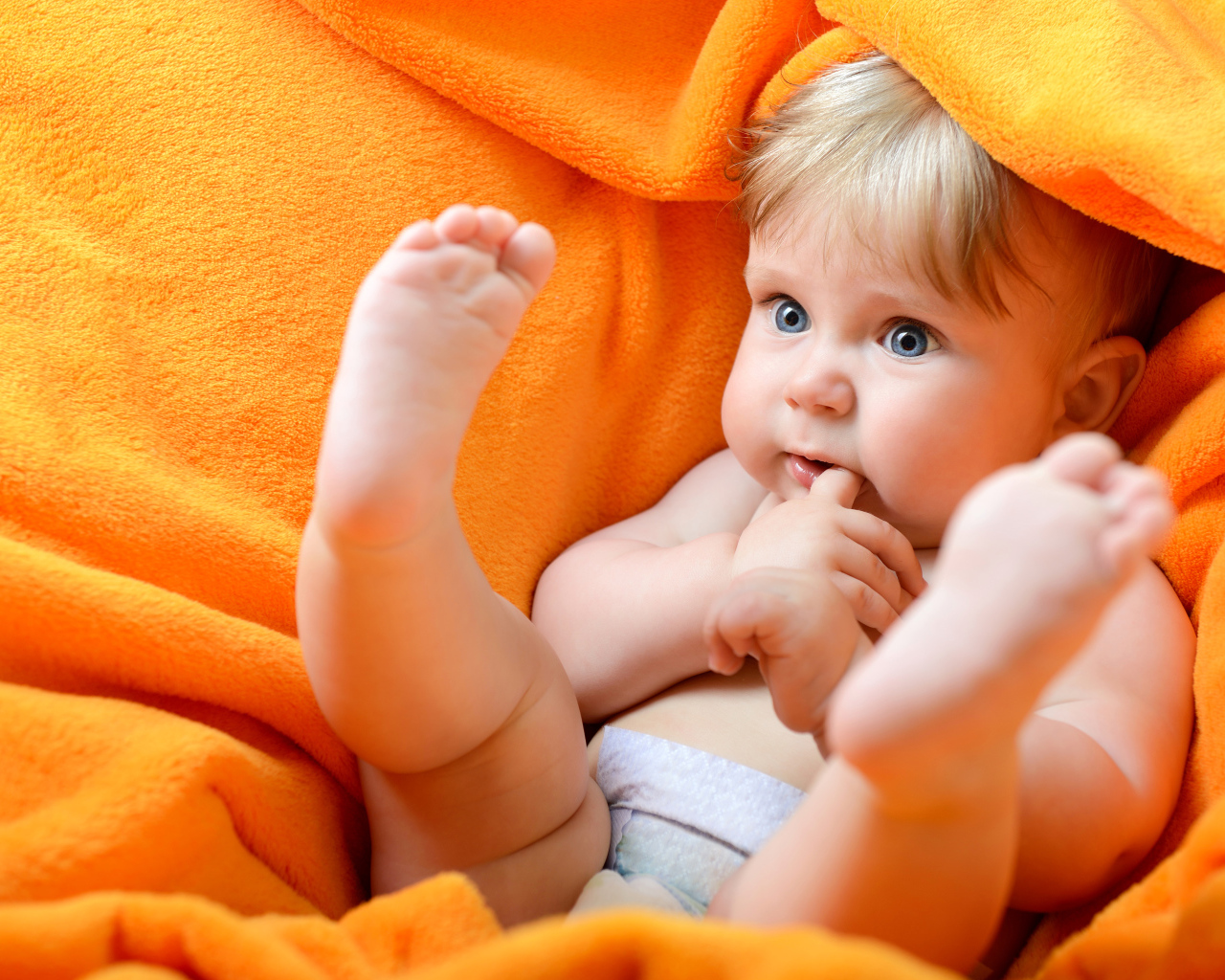 Маленький голубоглазый ребенок в желтом покрывале 