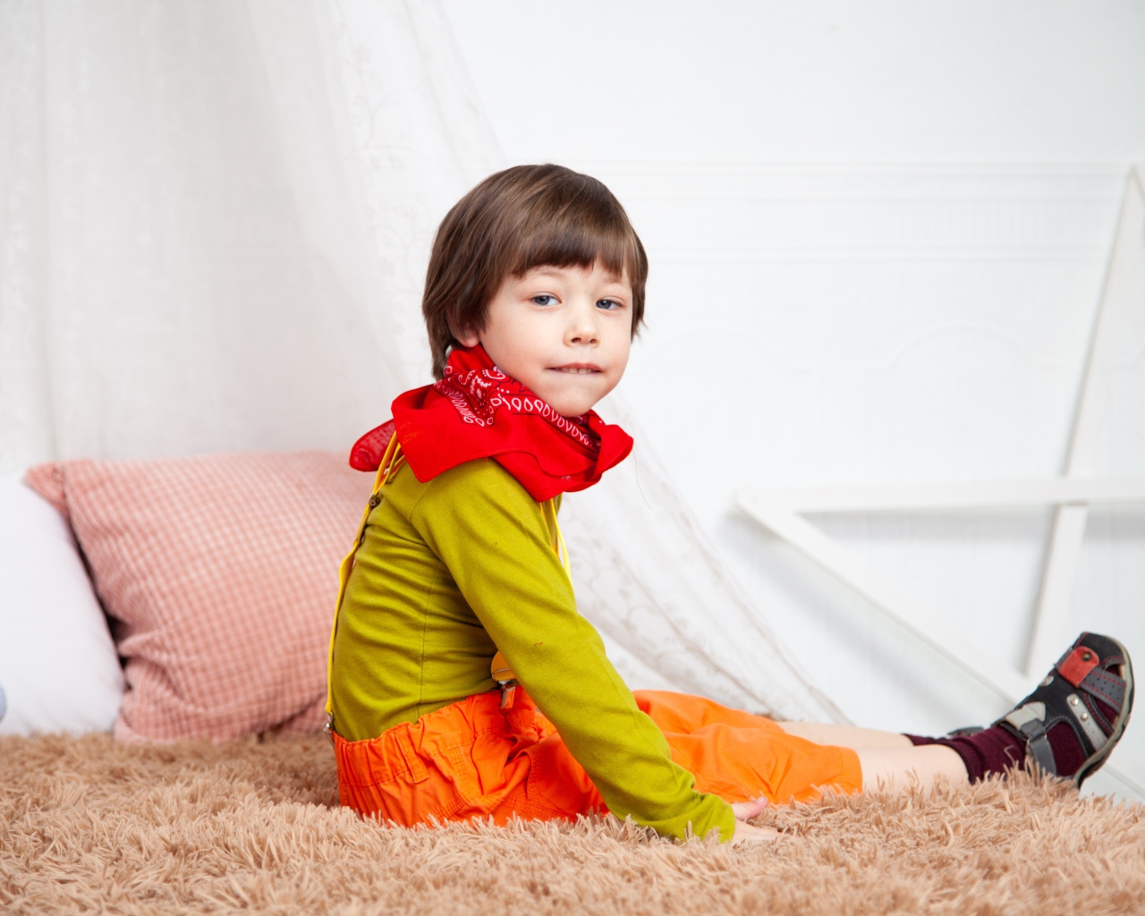 Маленький мальчик сидит на кровати