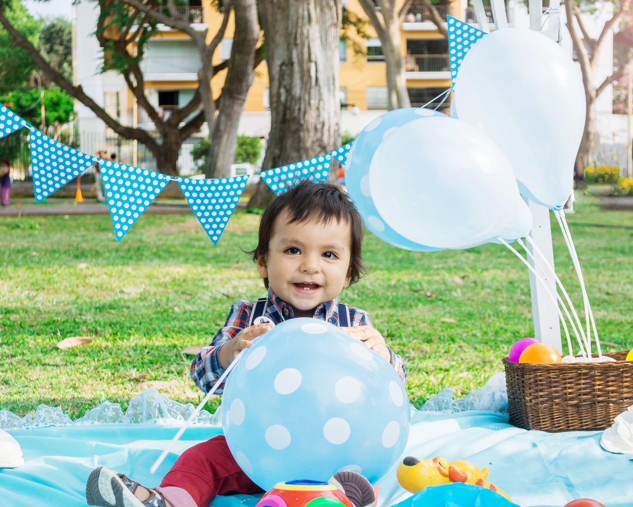 Маленький мальчик с шарами и украшениями на день рождения 