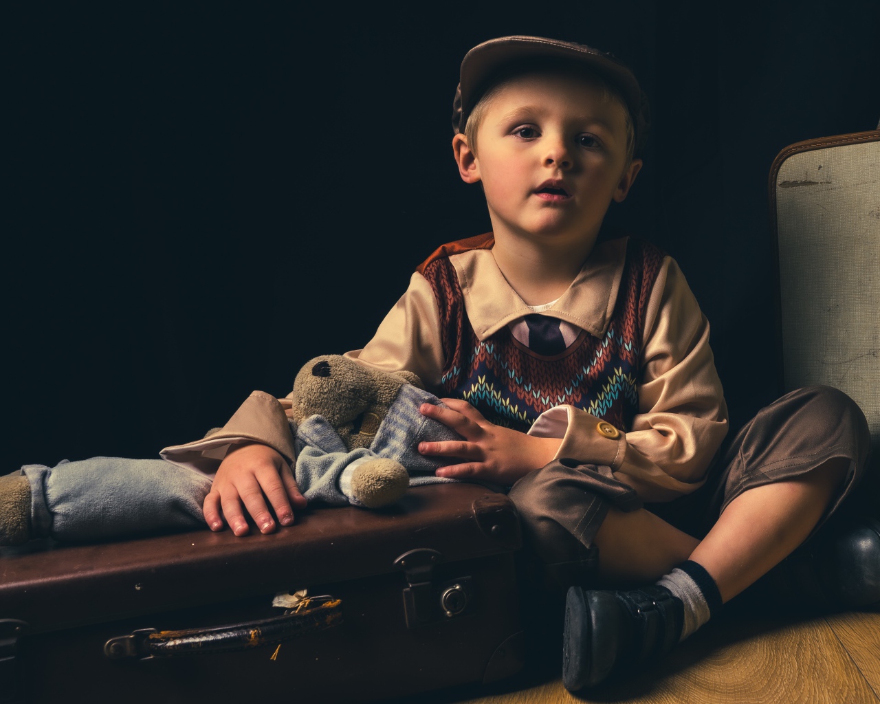 Маленький мальчик с чемоданом и игрушкой