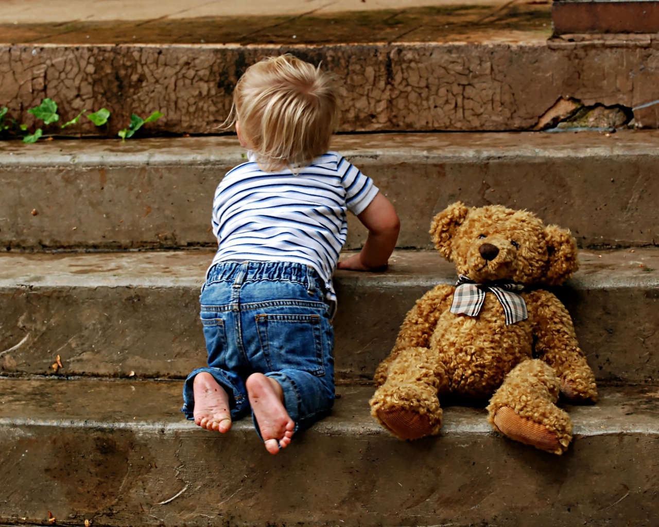 Маленький ребенок с медведем на ступеньках