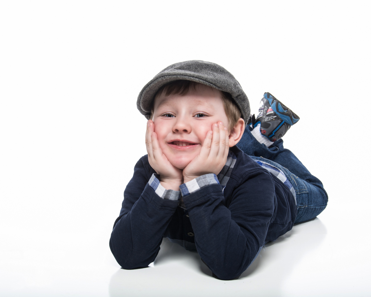 Маленький милый мальчик в кепке на белом фоне