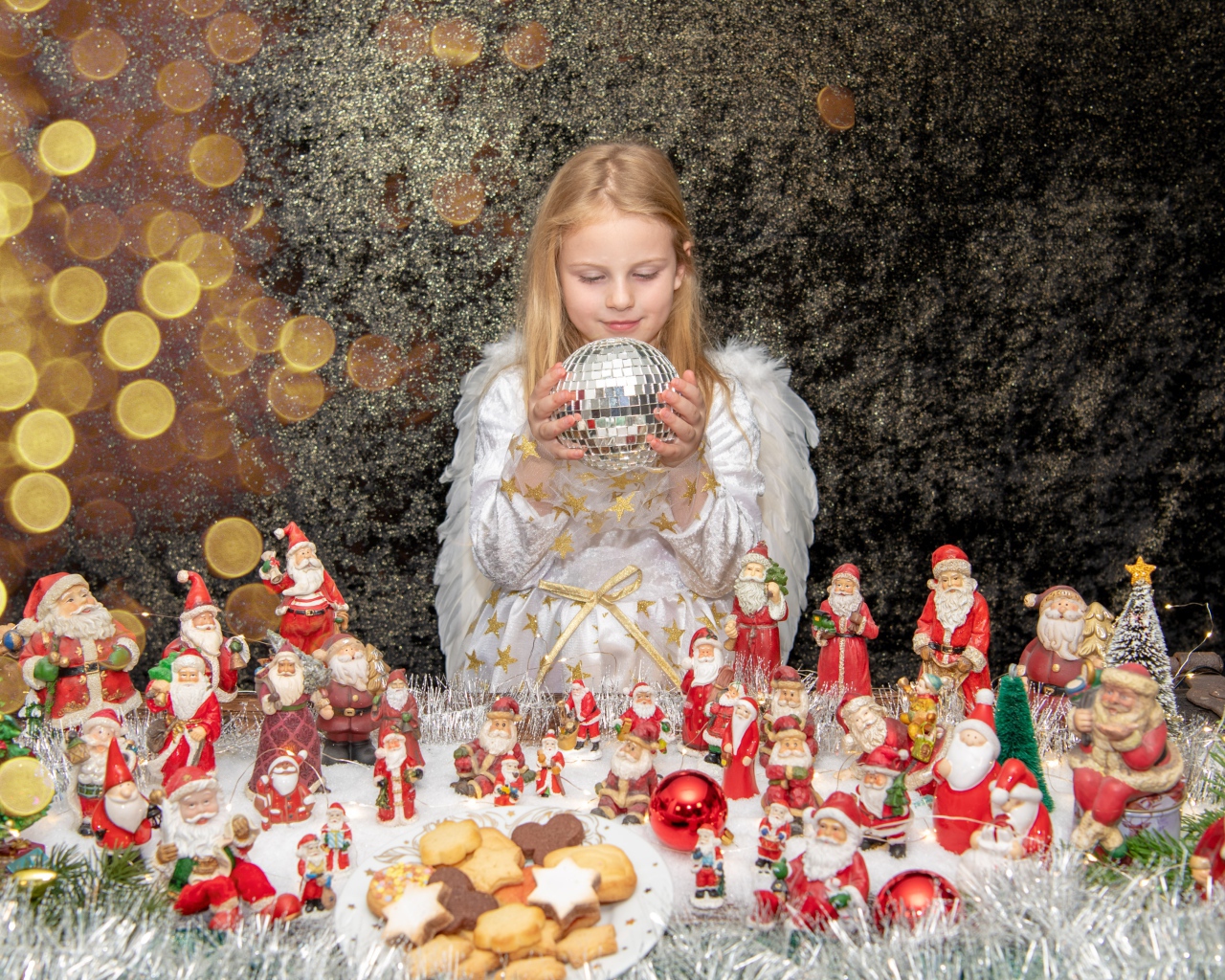 Маленькая девочка в костюме ангела с новогодним декором