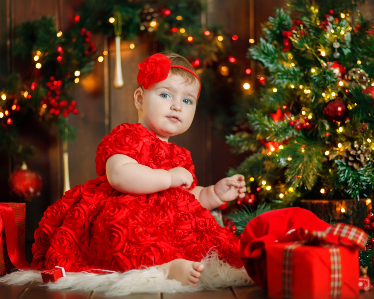 Маленькая девочка в красивом платье у наряженной ели 