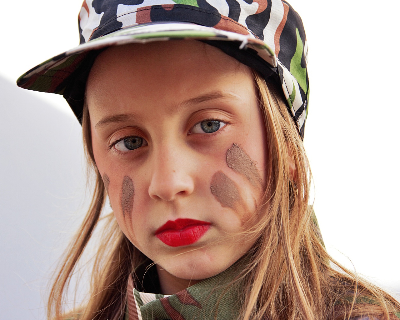 Маленькая девочка в кепке с грязью на лице