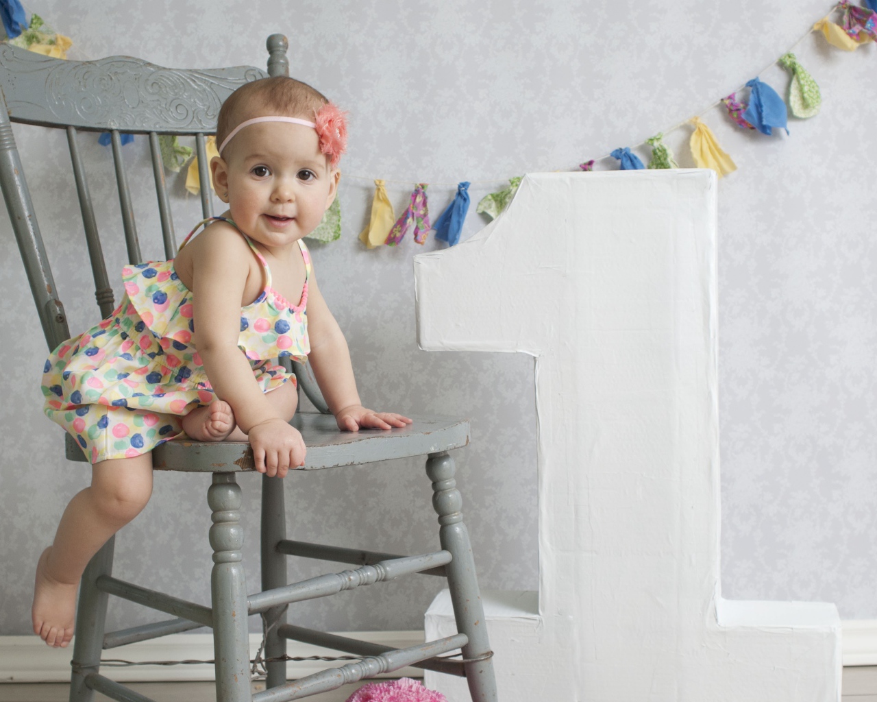 Маленькая девочка в платье на стуле