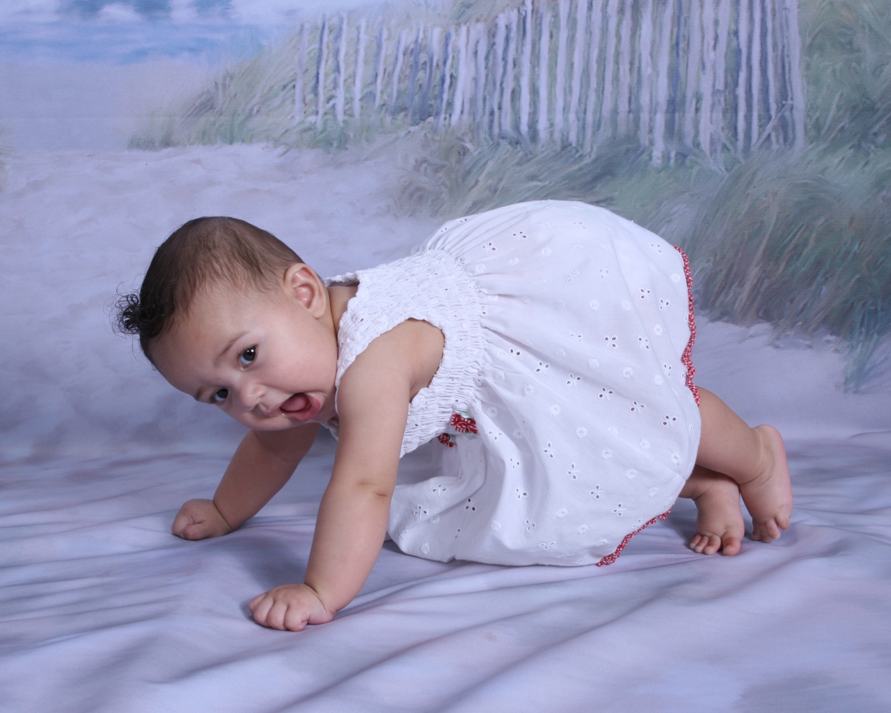 Маленькая девочка в белом платье на кровати 