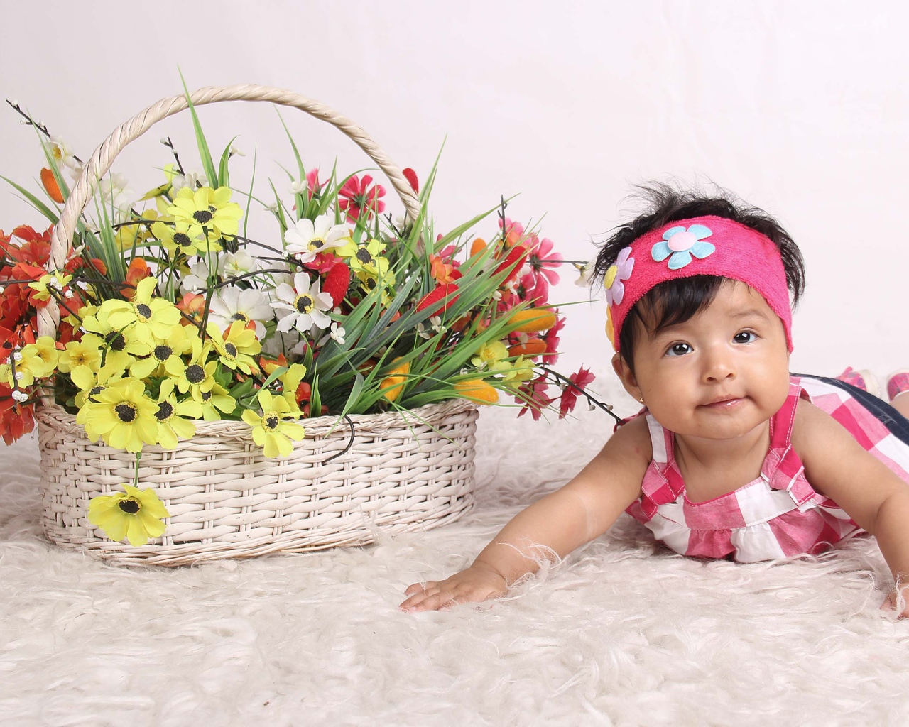 Маленькая девочка рядом с корзиной цветов 