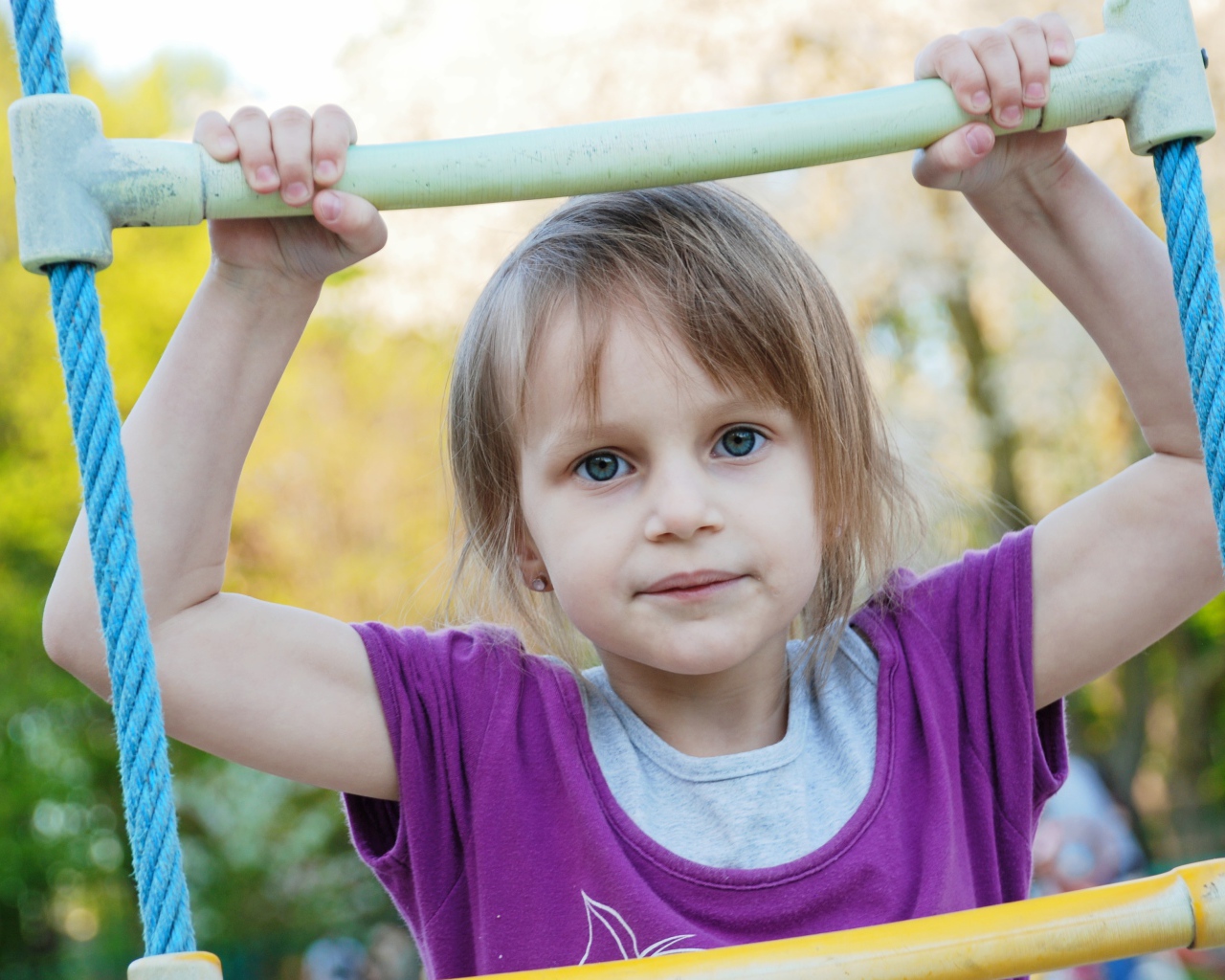 Маленькая девочка на подвесной лестнице 