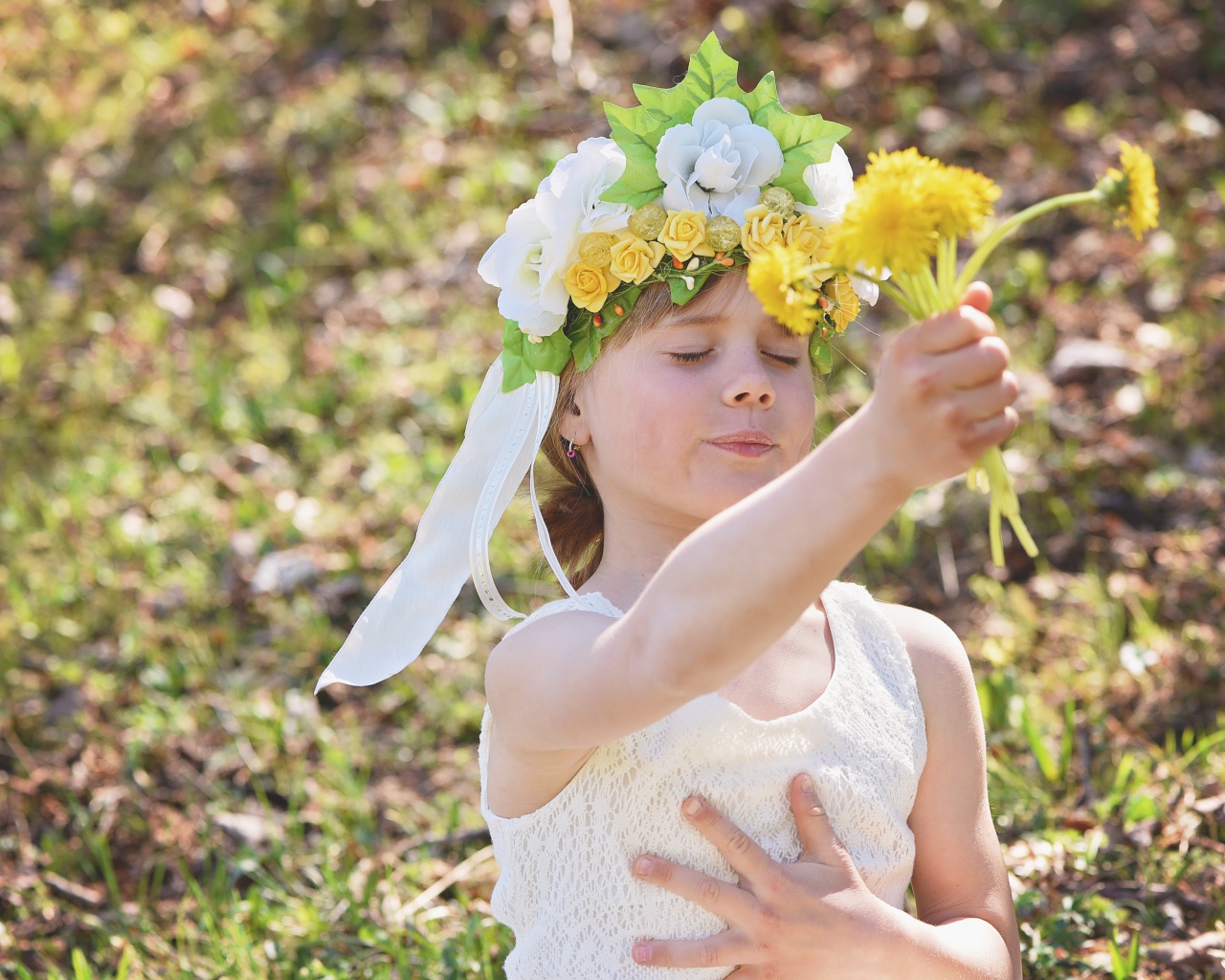 Маленькая девочка с букетом одуванчиках в руке 