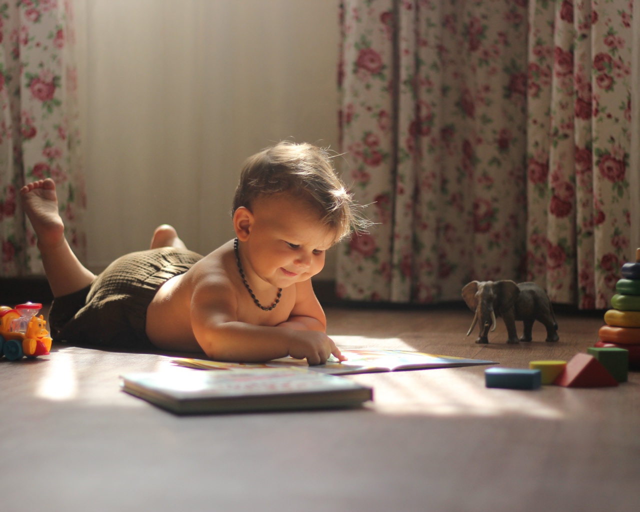 Маленькая девочка с книгами на полу в комнате