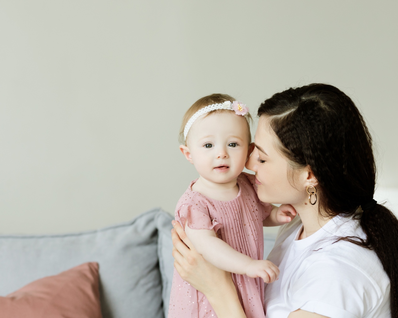 Маленькая девочка с мамой на сером фоне