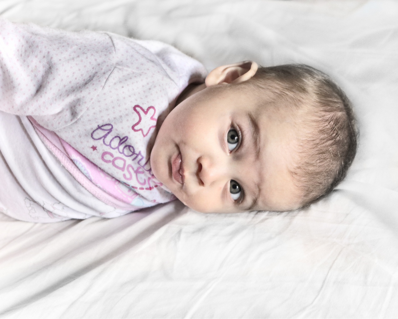 Маленький новорожденный ребенок лежит на кровати 