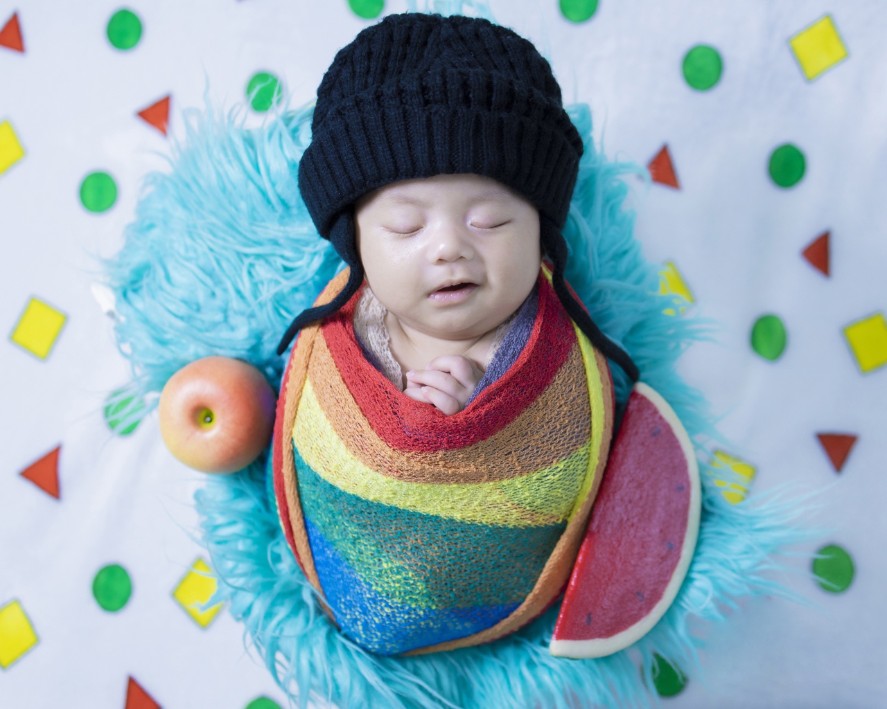 Маленький спящий ребенок в черной шапке 