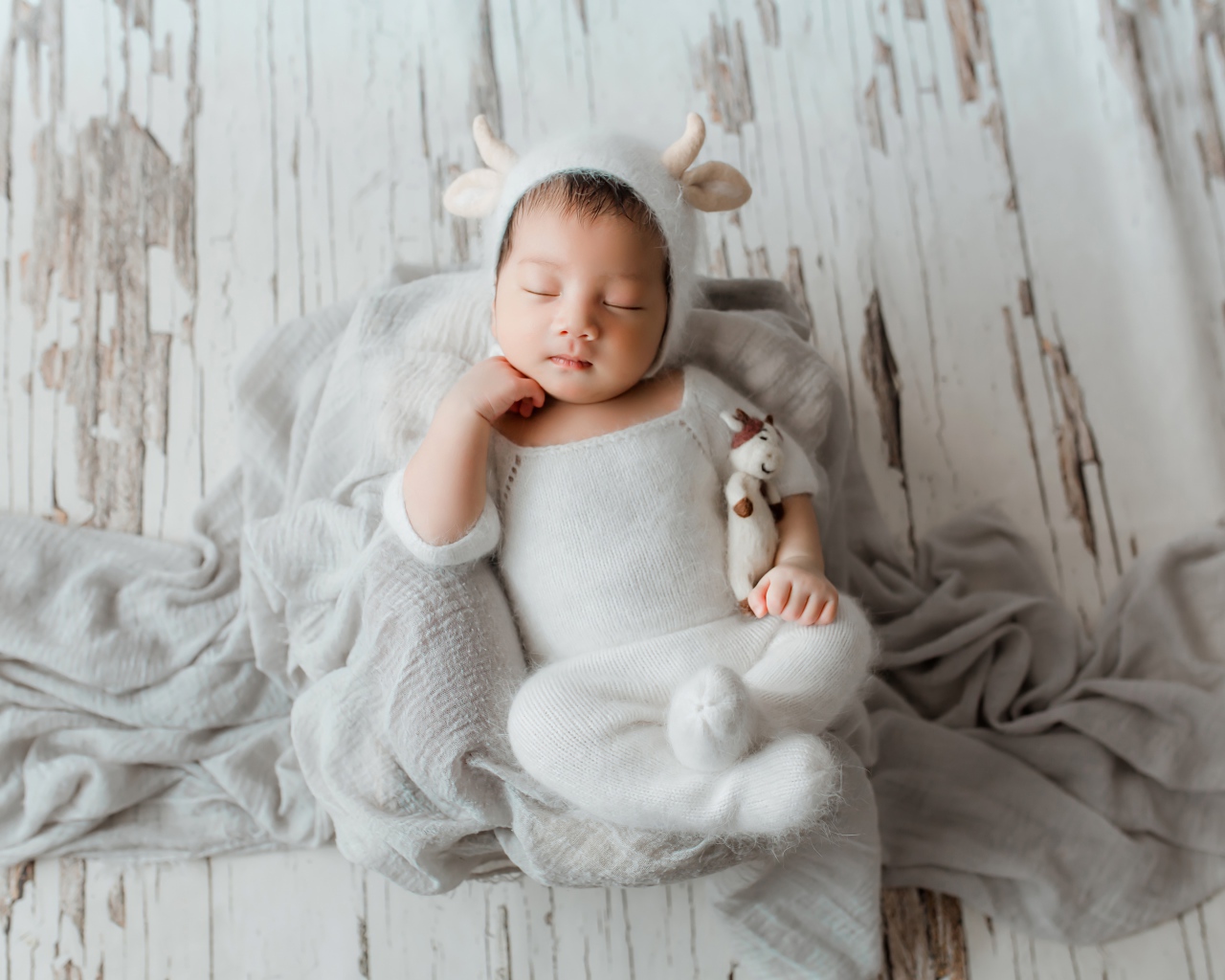 Маленький спящий грудной ребенок в белом костюме