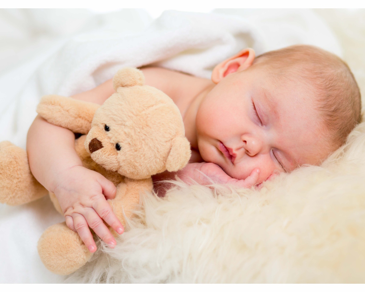 Новорожденный ребенок спит с игрушечным медведем