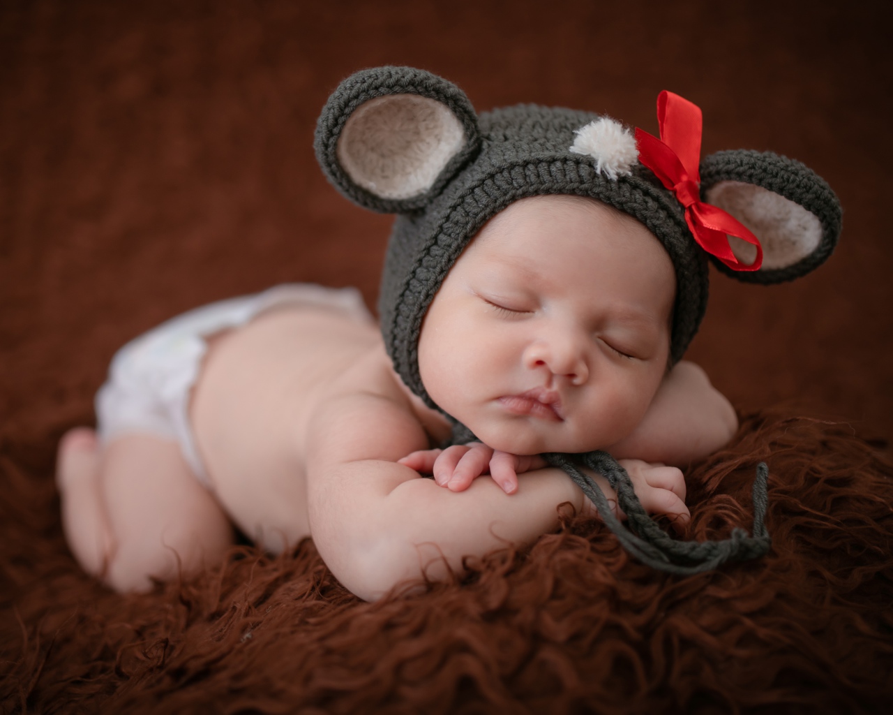 Новорожденный спящий ребенок в шапке мышонка 