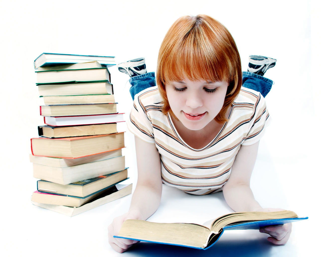 Рыжеволосая девочка школьница с книгами на белом фоне 