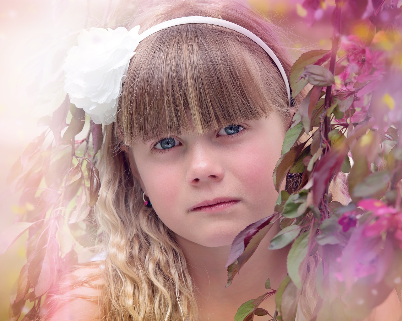 Грустная маленькая девочка у ветки дерева 