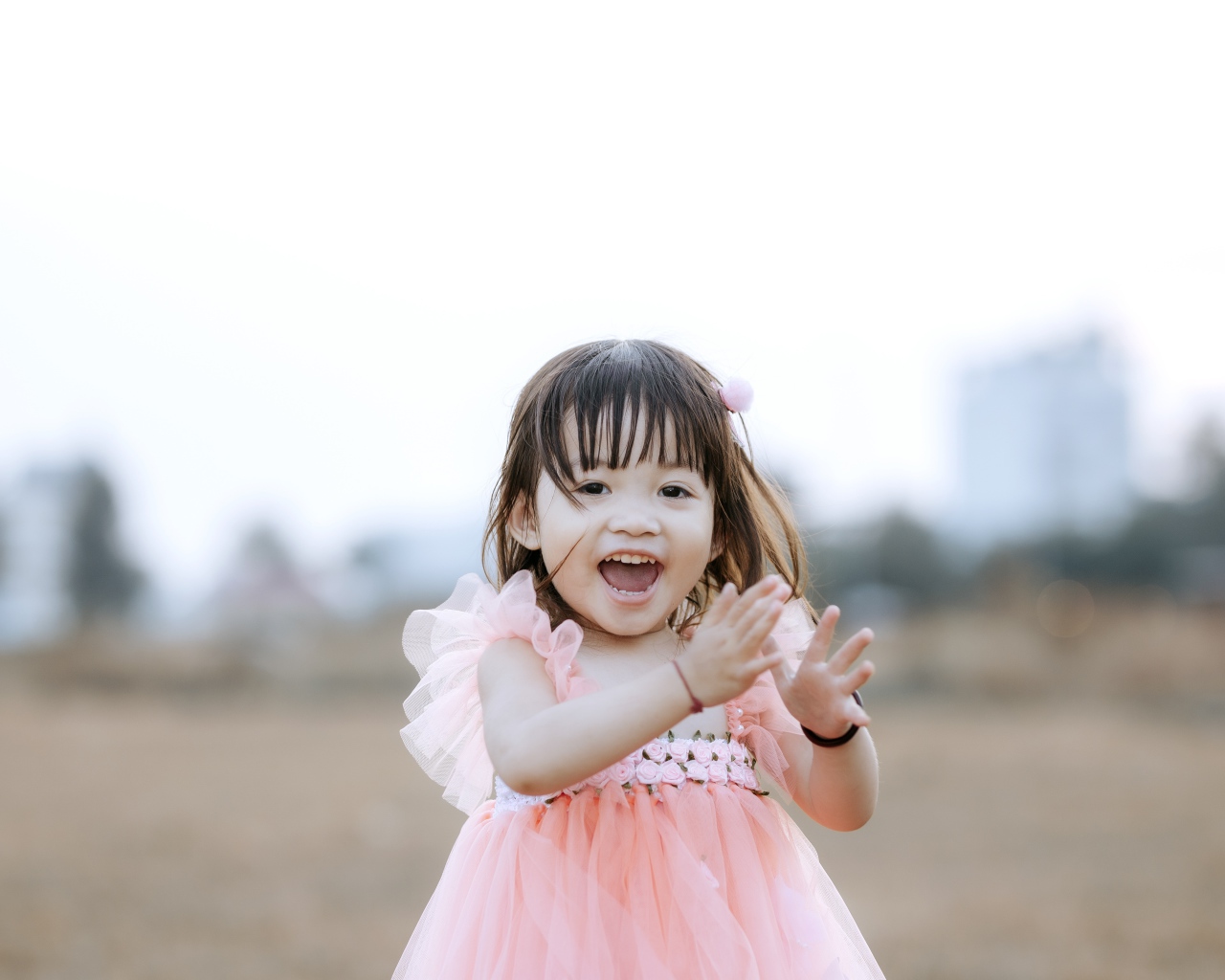 Довольная маленькая девочка в розовом платье 