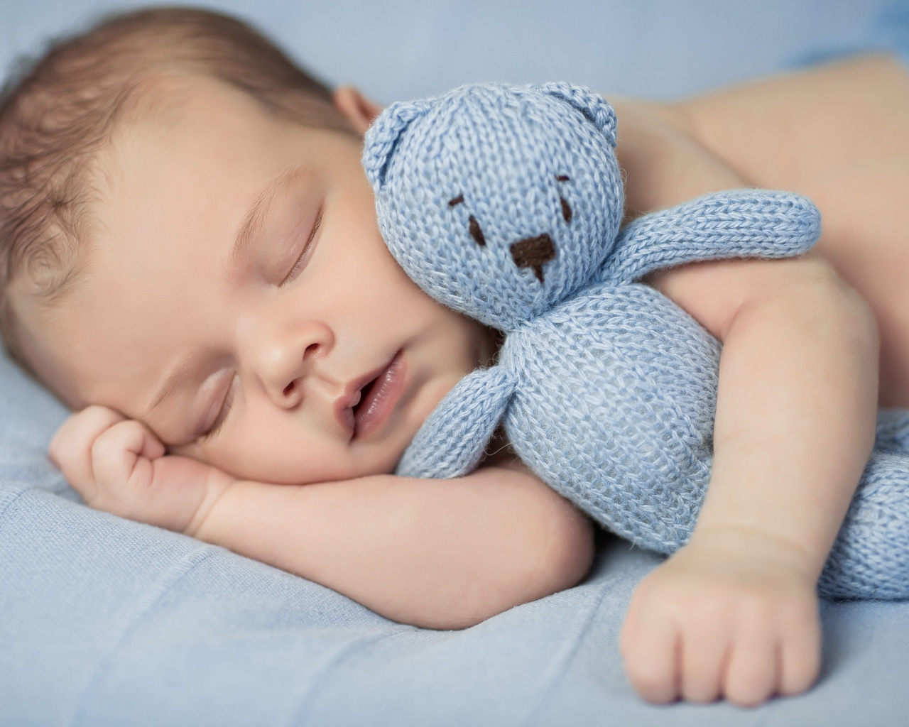 Маленький грудной ребенок с вязаным мишкой