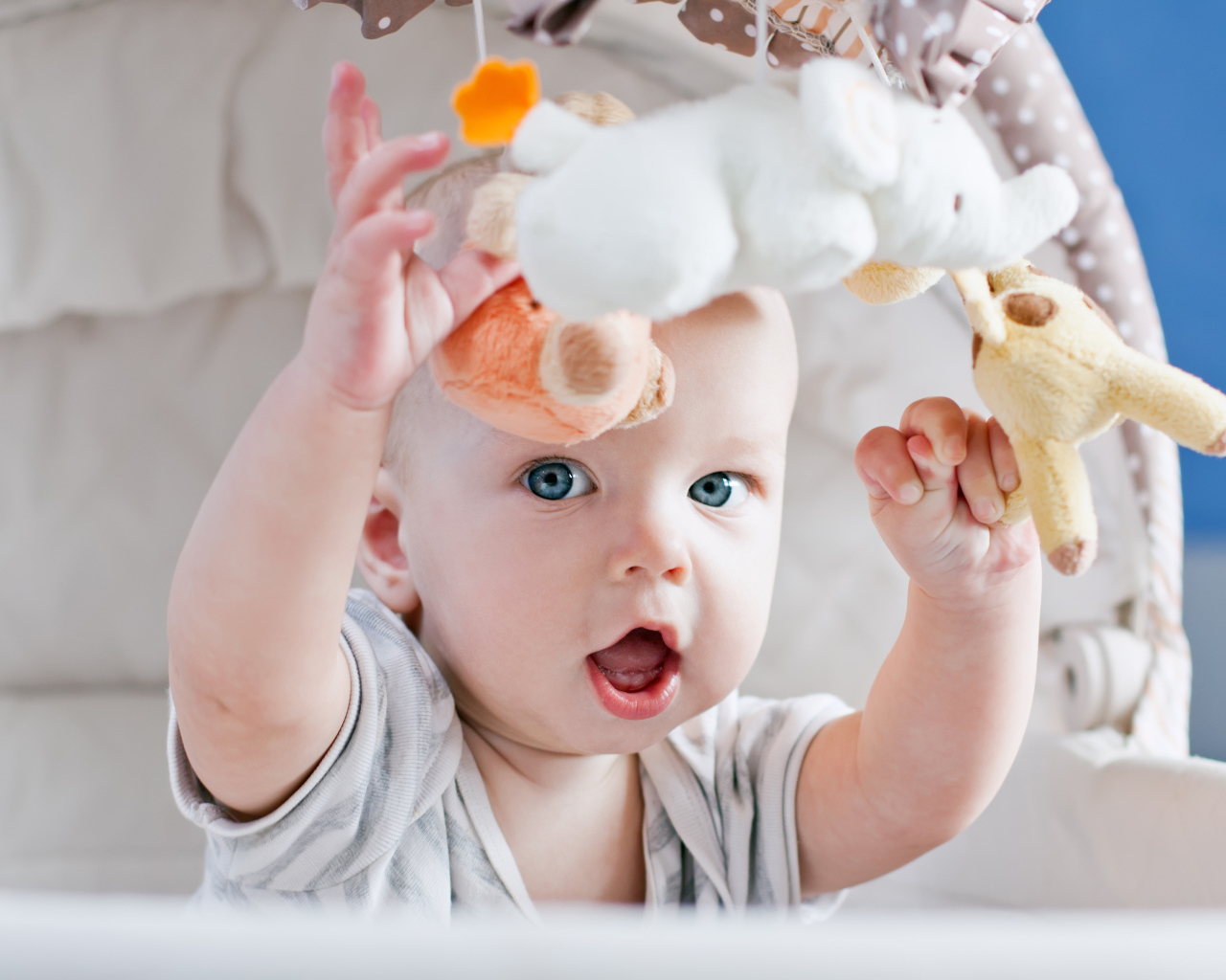 Маленький грудной ребенок в коляске с игрушками 