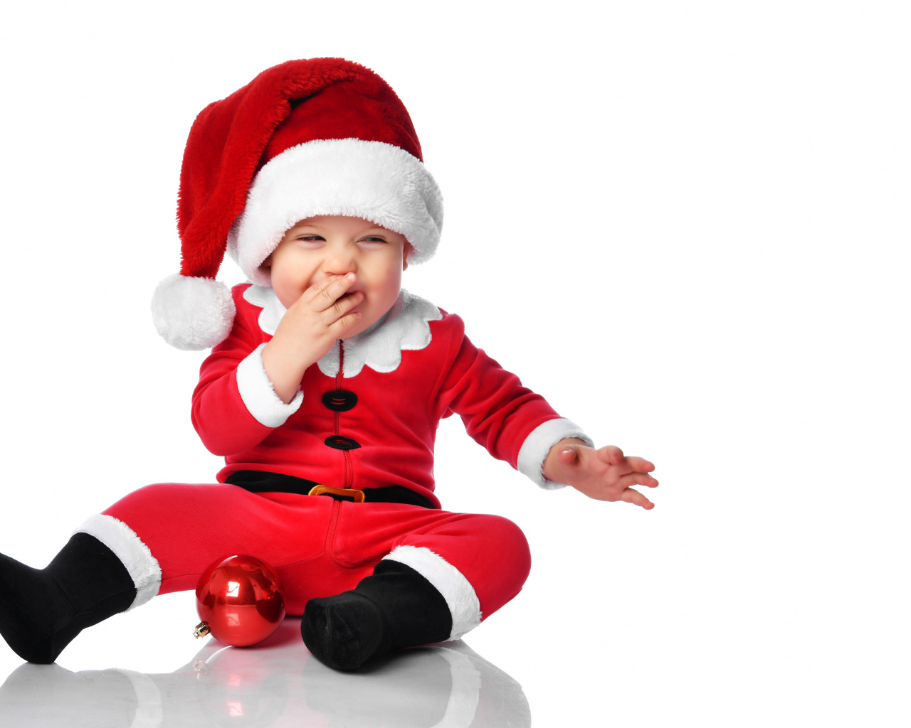 Улыбающийся ребенок в новогоднем костюме на белом фоне 