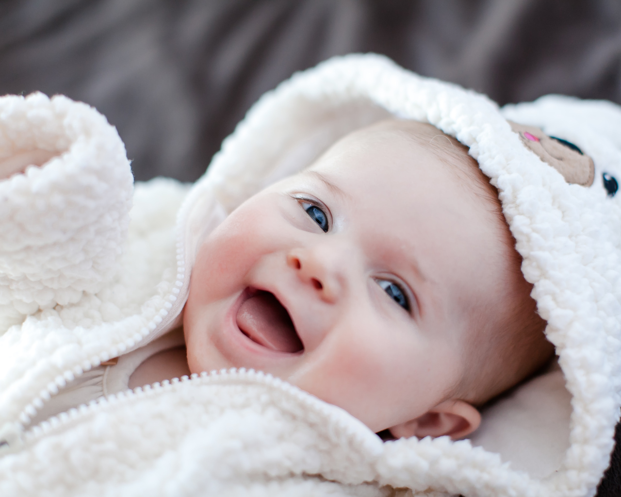 Улыбающийся милый ребенок в теплом костюме 