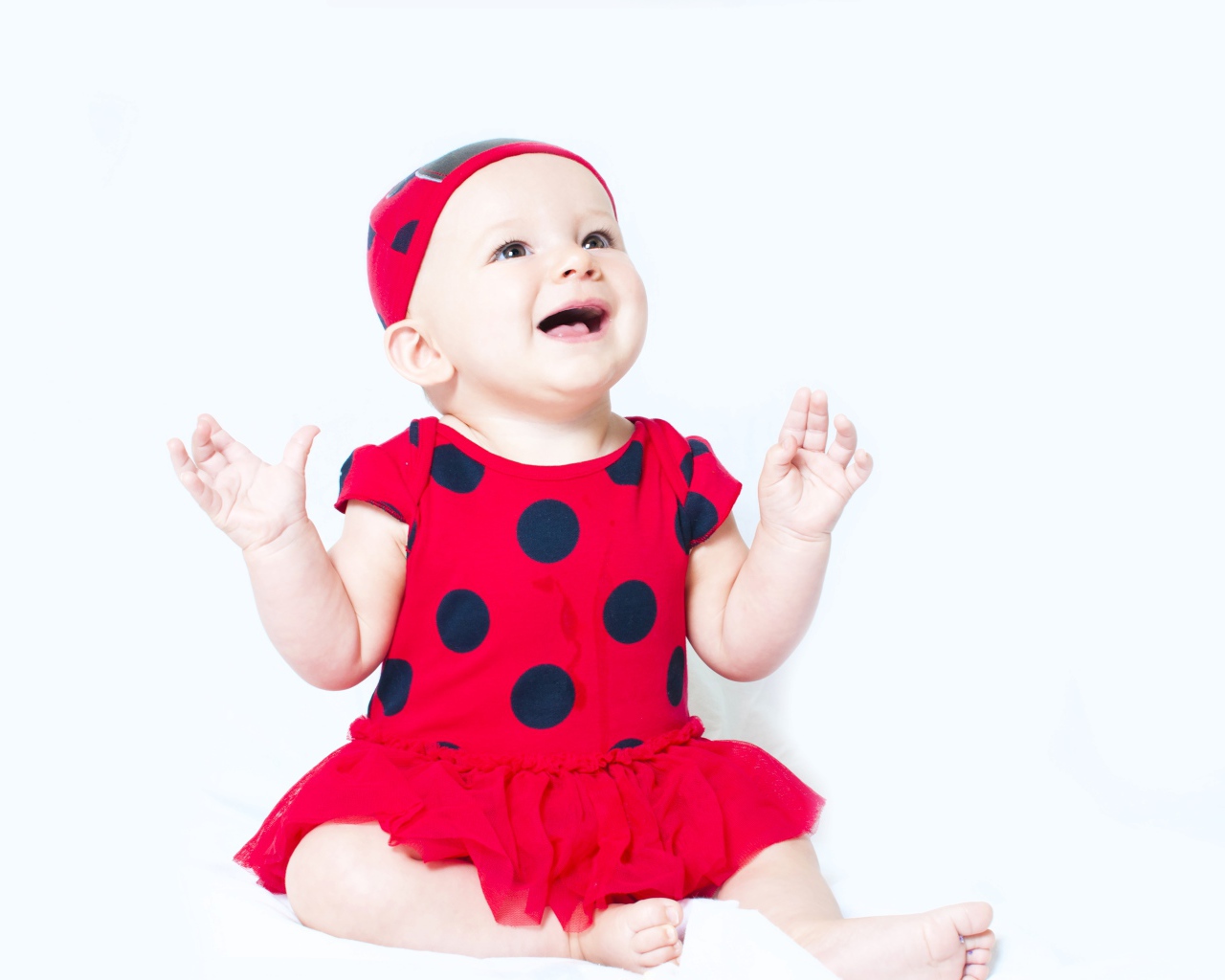 Улыбающаяся девочка в красном платье с черными кругами