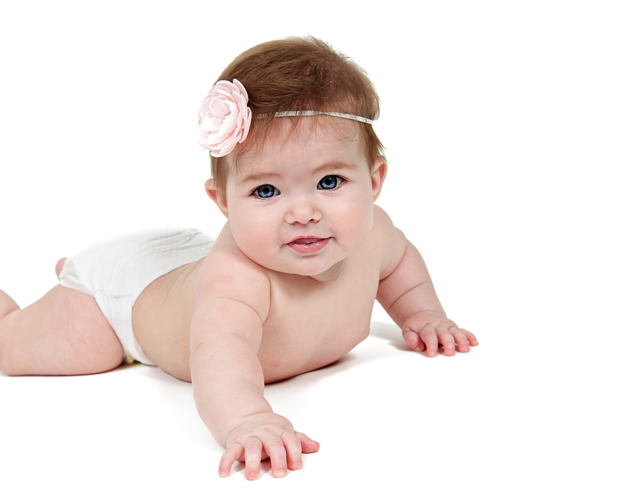 Улыбающаяся маленькая голубоглазая малышка на белом фоне 