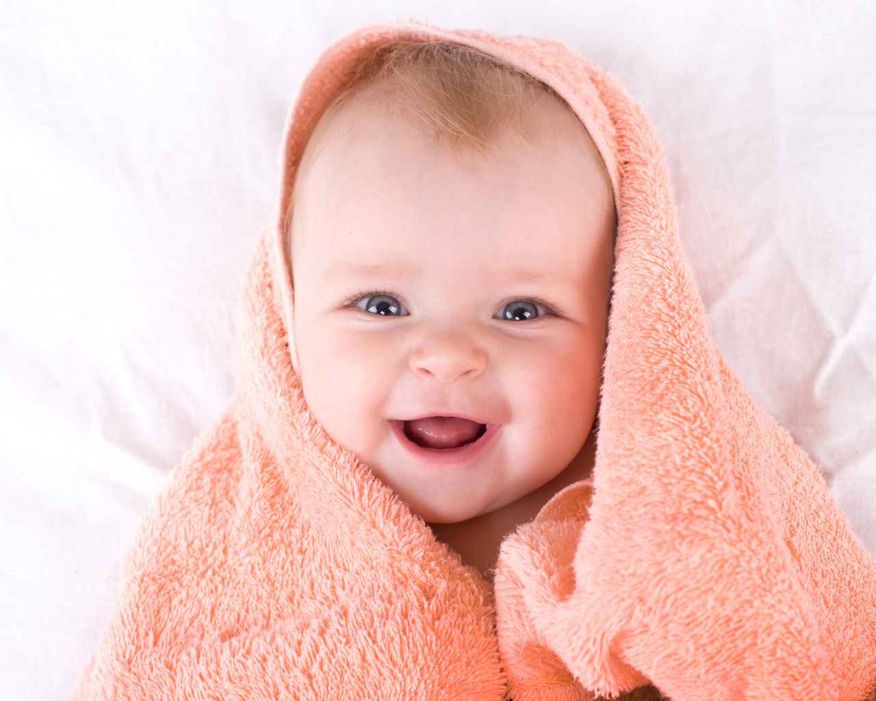 Улыбающийся грудной ребенок в полотенце