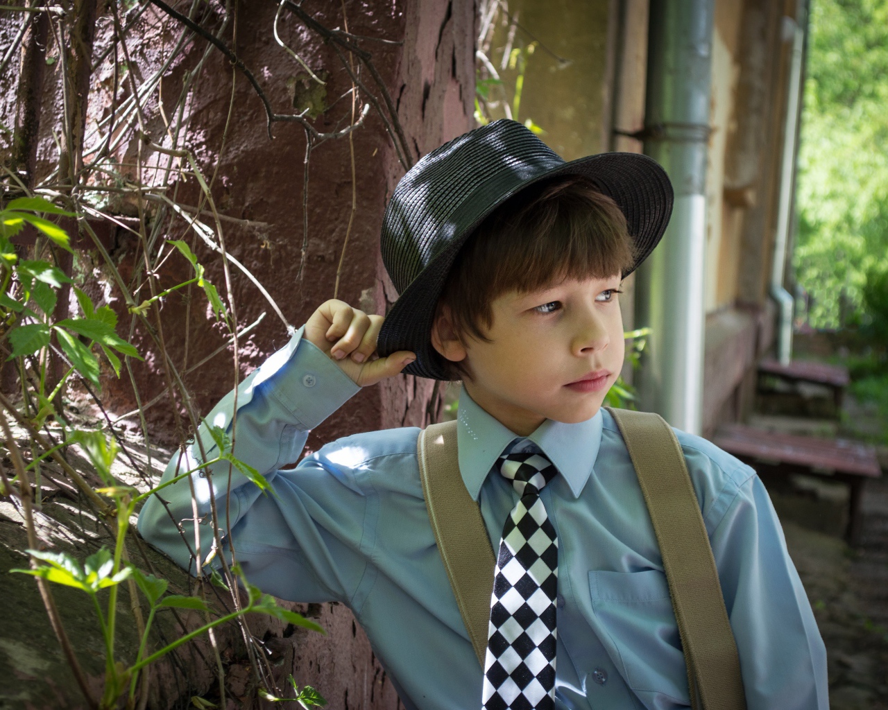 Стильный мальчик в черной шляпе 