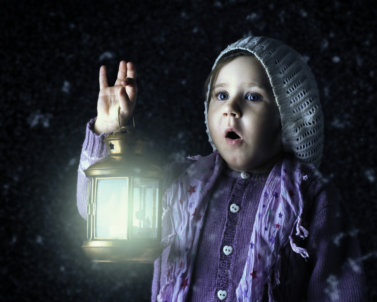 Удивленная маленькая девочка с фонарем в руке