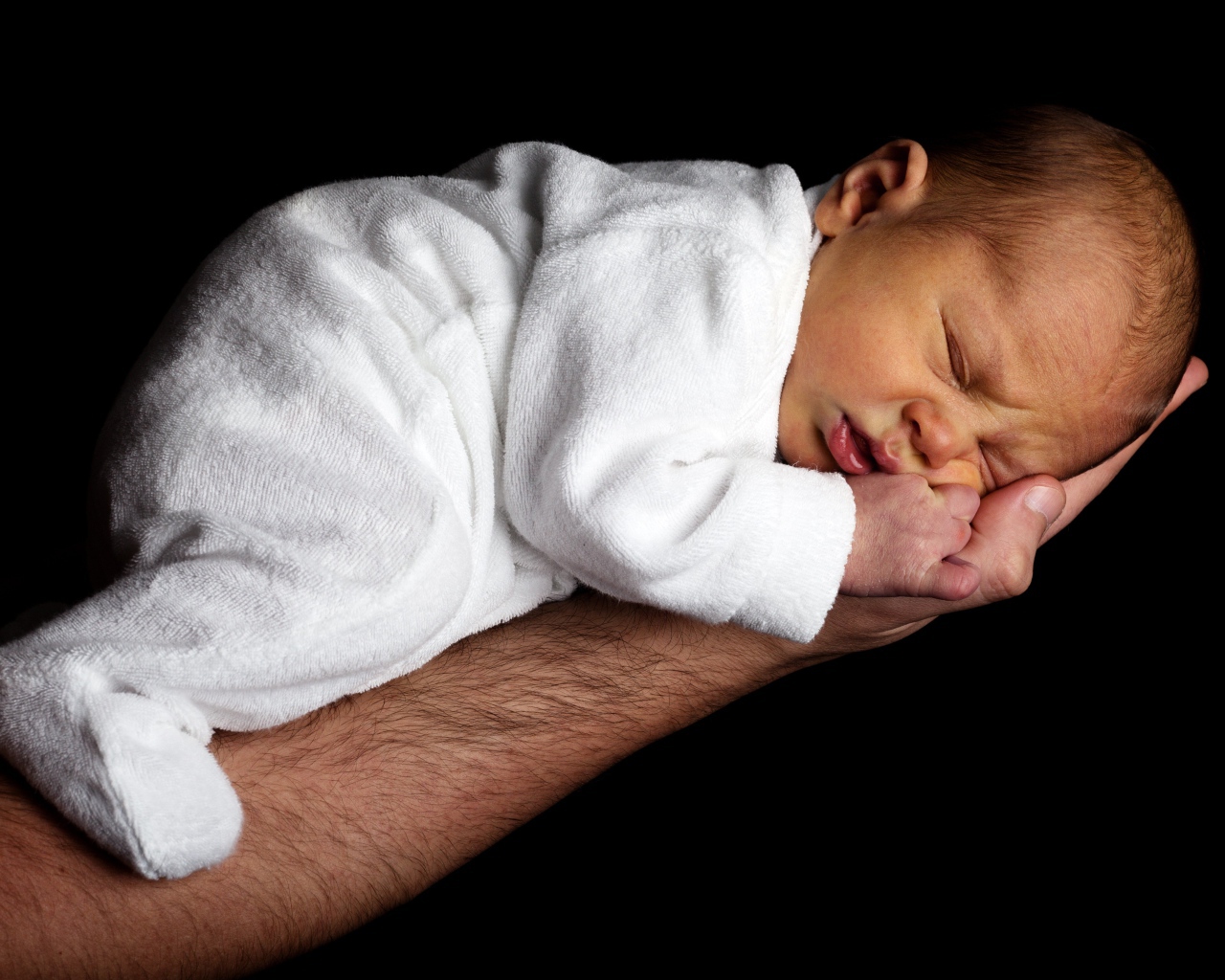 Грудной ребенок спит на руке у папы