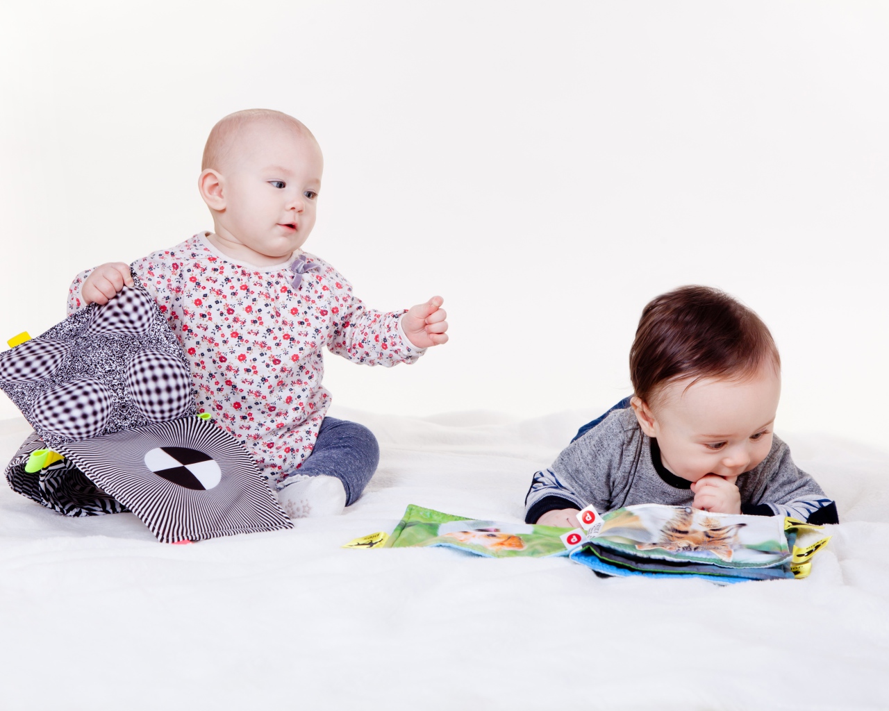 Два маленьких ребенка играют на белом фоне