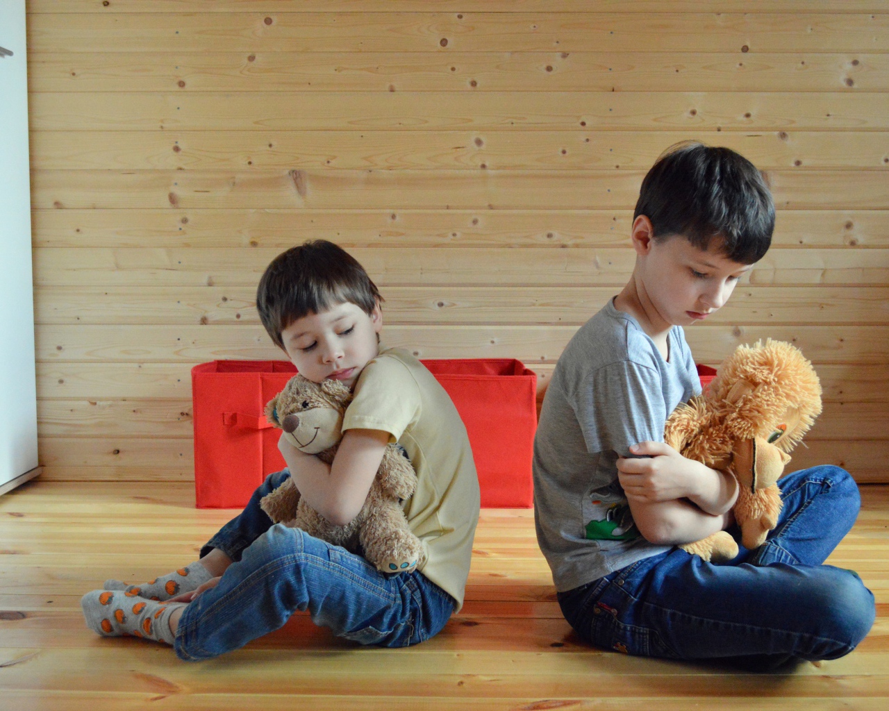 Два маленьких обиженных мальчика сидит на земле