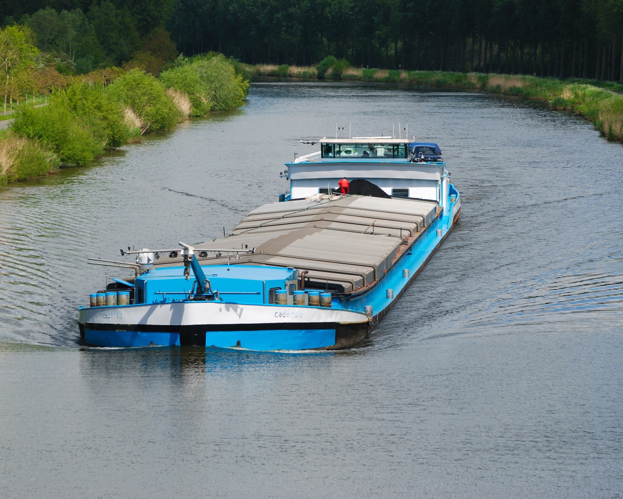Грузовая баржа плывет по реке 