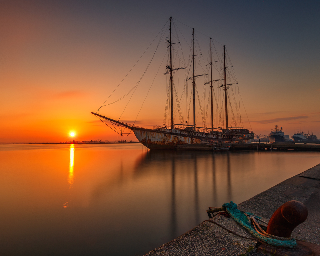 Большой корабль стоит на закате солнца 