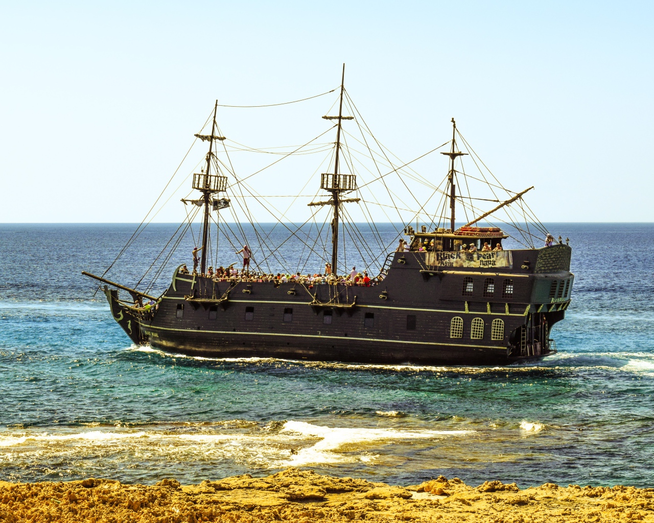 Big black pirate ship off the coast