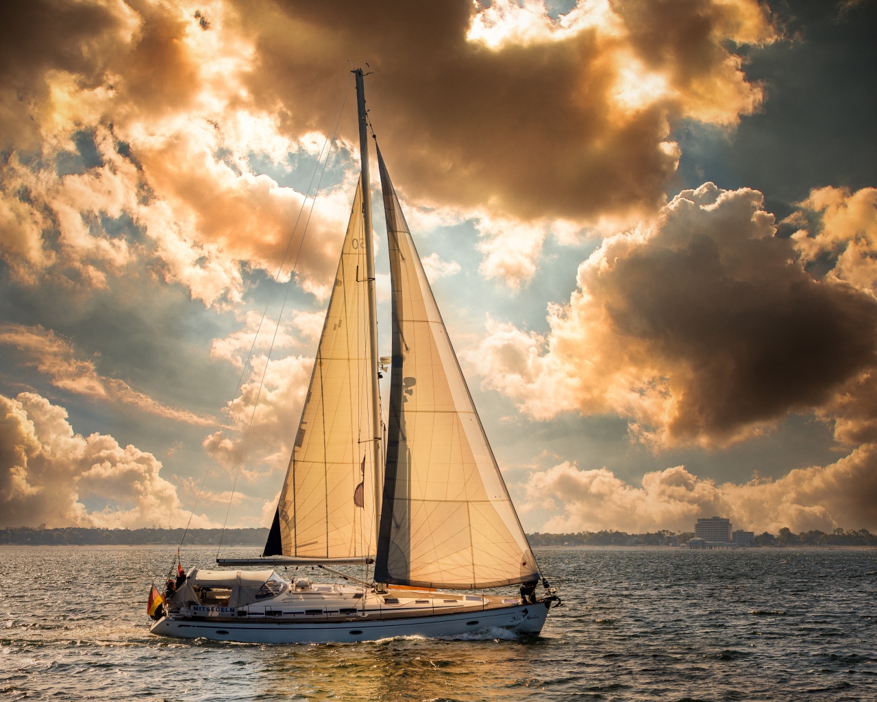 Большая парусная яхта в море на закате 