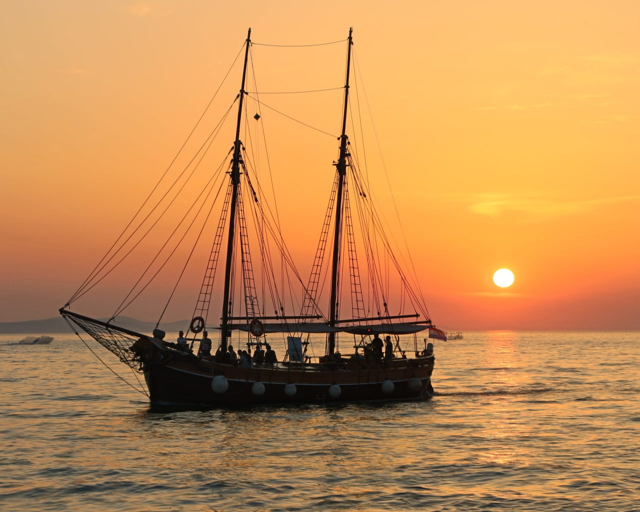 Большой корабль с опущенными парусами на закате солнца 
