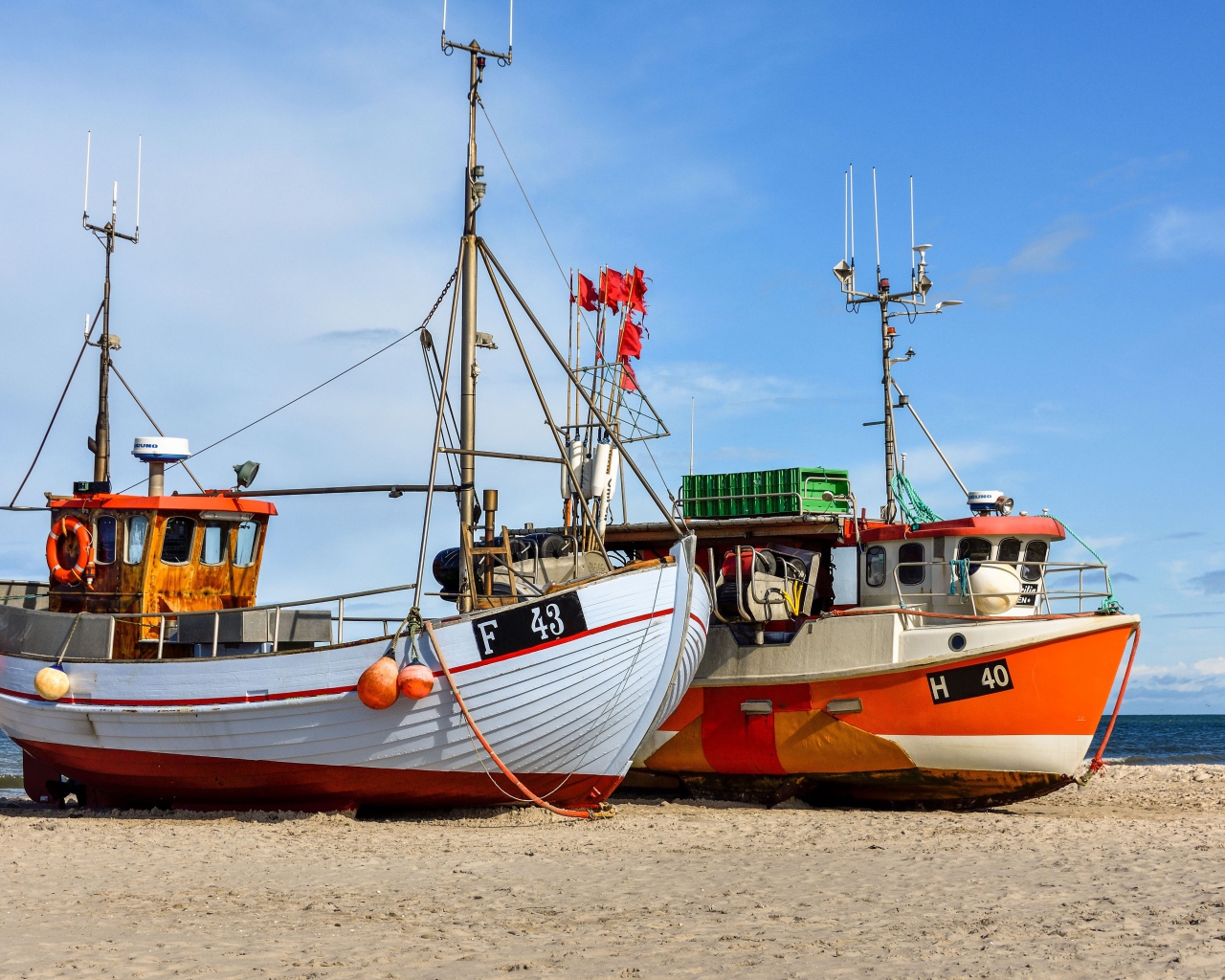 Две рыбацкие лодки стоят на песке у моря 