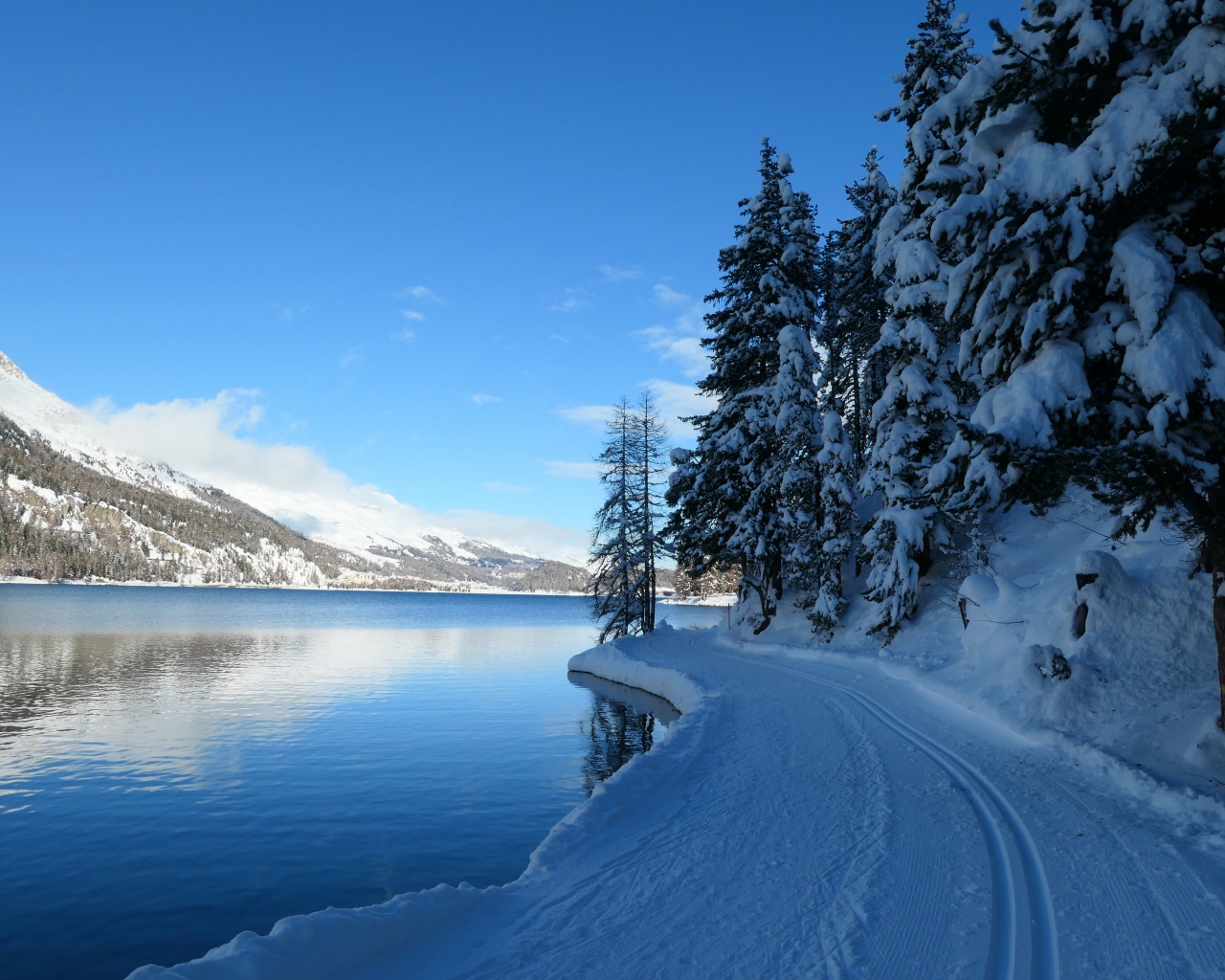 Snow covered road by the lake